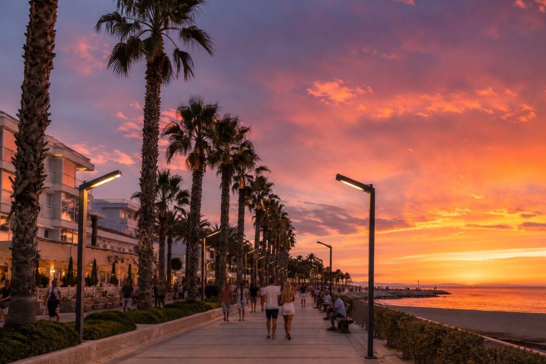 Paseo marítimo de Salou al atardecer con palmeras, edificios turísticos y el mar Mediterráneo al fondo