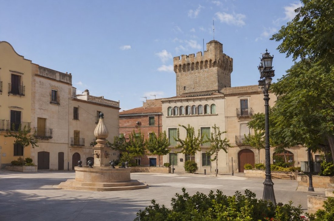 Plaza del núcleo urbano de Vila-seca con la torre medieval del castillo y edificios tradicionales