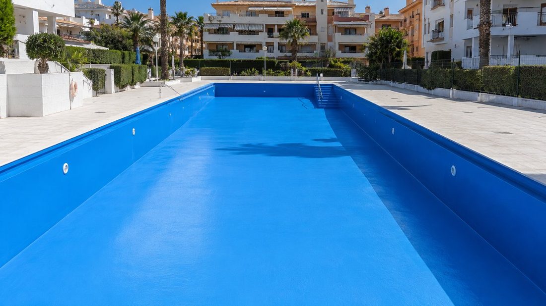 Piscina comunitaria de un complejo residencial de Cambrils tras el pintado con esmalte epoxi azul claro